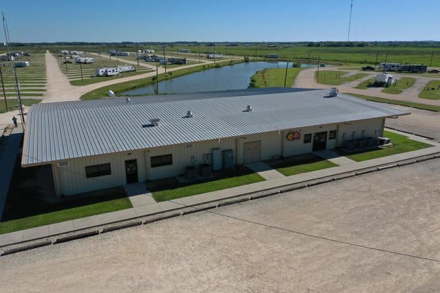Exterior of American Dream RV Park main building with metal roof and RV sites behind