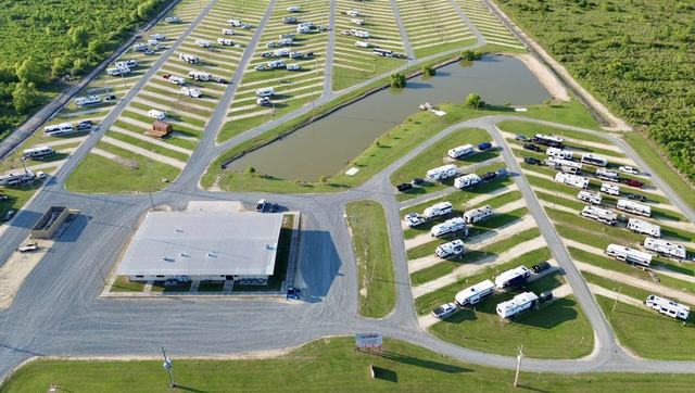 Aerial view of American Dream RV Park with main building, pond, and RV rows