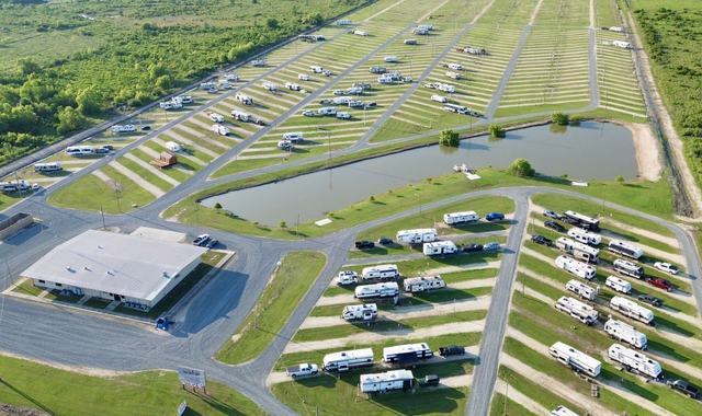 Aerial view of RV rows surrounding a pond and main building at American Dream RV Park