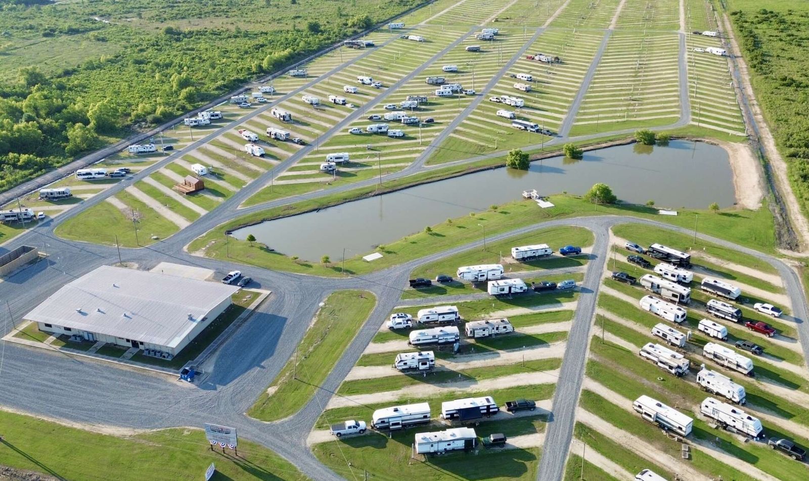 Aerial view of RV rows surrounding a pond and main building at American Dream RV Park