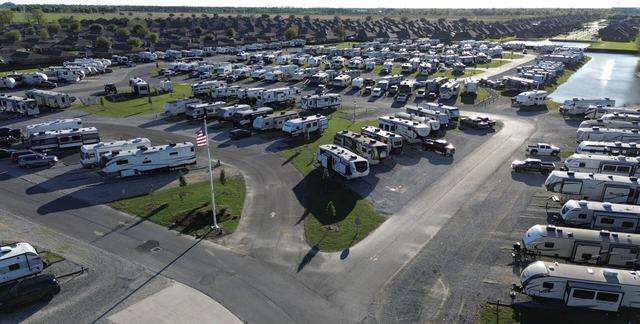 Aerial view of The Gates at McNeese RV Park with a flagpole and rows of RVs
