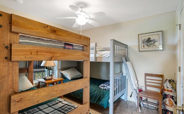 Bunk room with wooden bunk bed and gray bunk bed with ladder