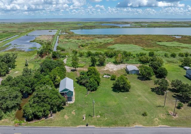 Aerial view of Pecan Island Camp house, shed, and lot with marsh beyond