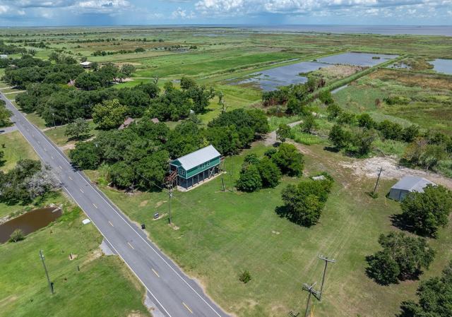 Aerial view of Pecan Island Camp beside a highway surrounded by trees and marsh