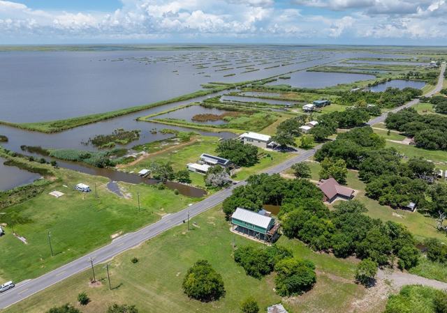 Aerial view of Pecan Island Camp along highway with marsh and open water