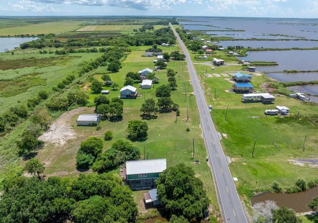 Aerial view of Pecan Island Camp near highway lined with homes and water