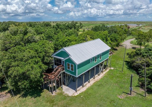 Aerial view of Pecan Island Camp elevated house among trees and marshland