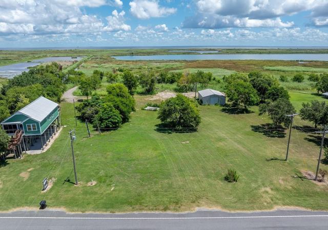 Aerial view of Pecan Island Camp lot with grassy yard, shed, and wetlands