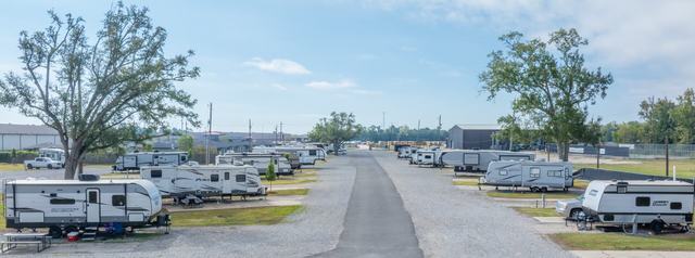 Rows of travel trailers lining a paved lane at Rustic Oak RV Park