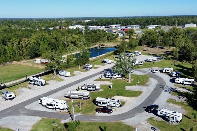 Aerial view of Rustic Oak RV Park with RVs along curving roads near a pond